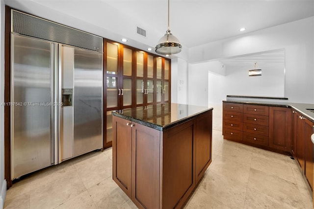 kitchen featuring hanging light fixtures, recessed lighting, stainless steel built in fridge, a kitchen island, and visible vents
