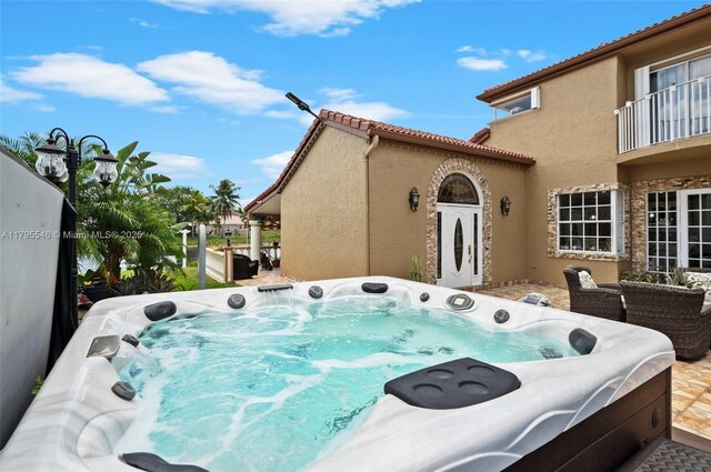 15870 NW 10th St, Pembroke Pines, FL 33028 - view of side of property with a hot tub, stucco siding, and a balcony
