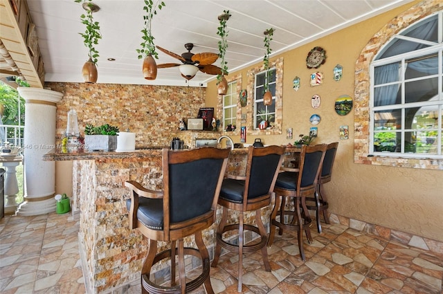 15870 NW 10th St, Pembroke Pines, FL 33028 - indoor bar featuring stone finish floors, a ceiling fan, a textured wall, and ornamental molding