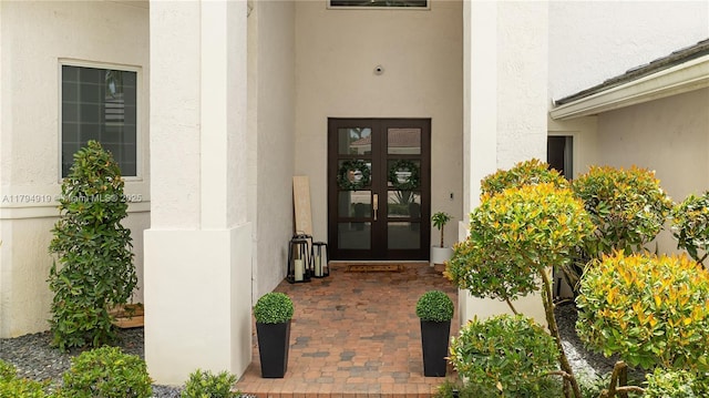 property entrance featuring french doors and stucco siding