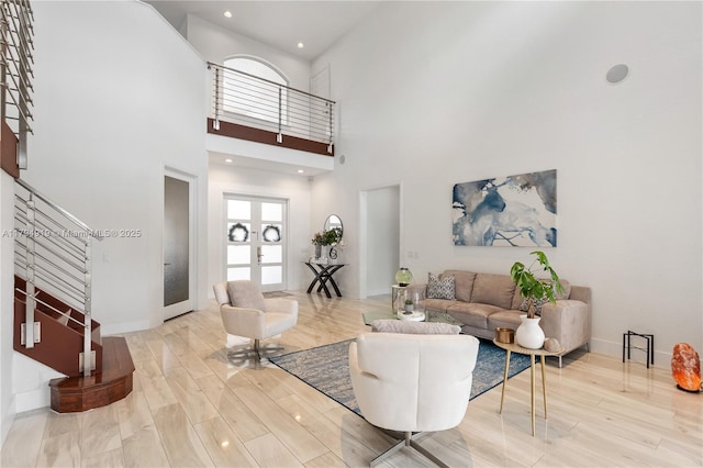 living room featuring baseboards, a high ceiling, recessed lighting, and wood finished floors