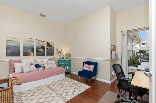 bedroom featuring visible vents, baseboards, and wood finished floors