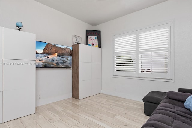 living area featuring baseboards and wood finished floors