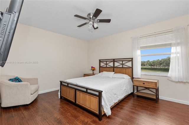 bedroom featuring a ceiling fan, baseboards, and dark wood-style floors