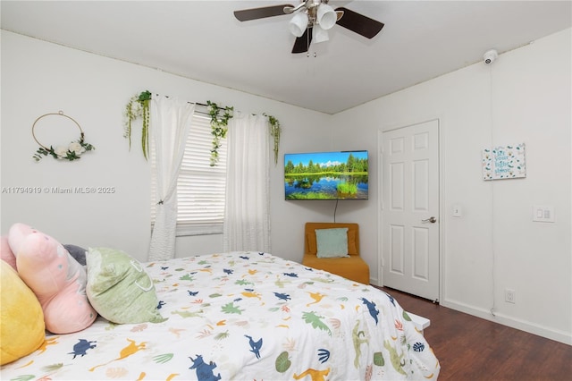 bedroom with a ceiling fan, baseboards, and wood finished floors