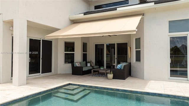 rear view of property featuring an outdoor hangout area, stucco siding, a patio area, and an outdoor pool