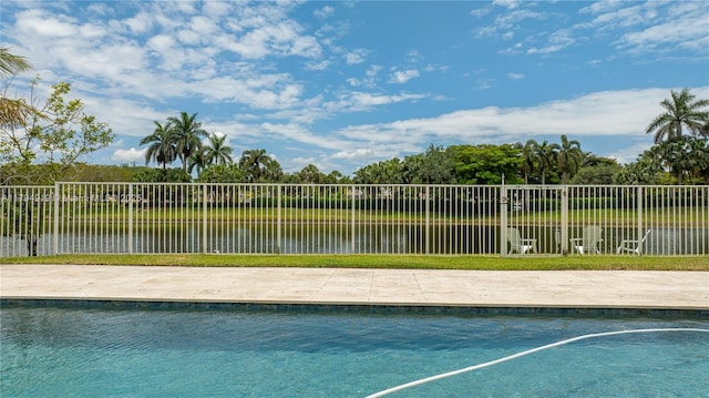 view of swimming pool featuring fence, a fenced in pool, and a water view