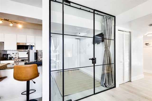 wine area featuring light wood-style floors and baseboards