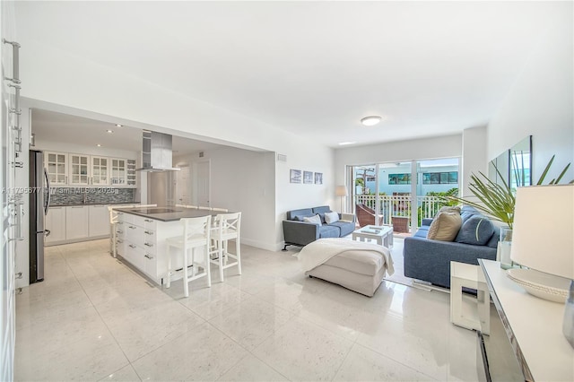 living room featuring baseboards, light tile patterned flooring, and visible vents