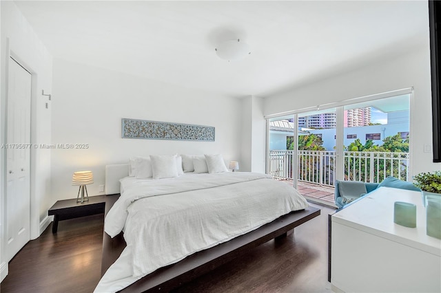 bedroom featuring baseboards, wood finished floors, and access to exterior