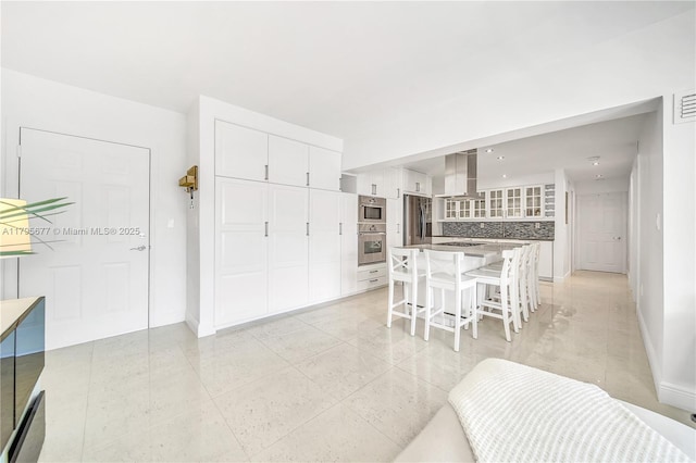interior space featuring baseboards, light tile patterned floors, and visible vents