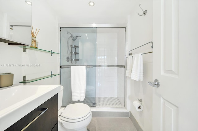 bathroom with vanity, a stall shower, and toilet