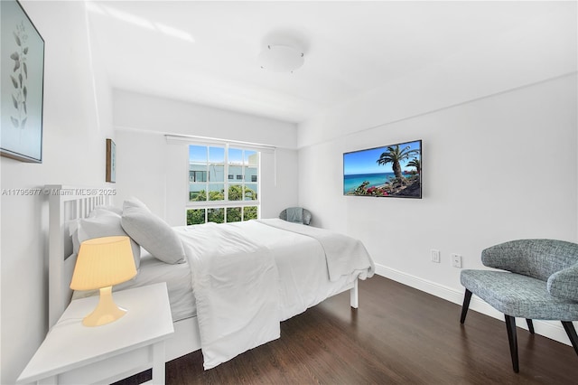 bedroom featuring baseboards and wood finished floors