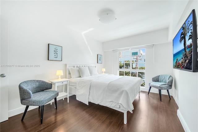 bedroom featuring baseboards and dark wood finished floors