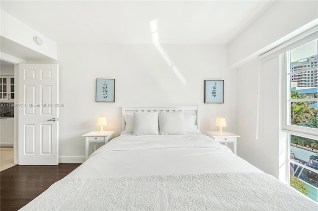bedroom with dark wood-type flooring and baseboards