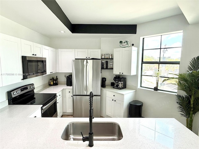kitchen with a sink, appliances with stainless steel finishes, light countertops, and a healthy amount of sunlight