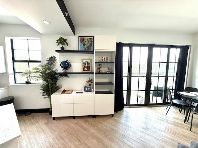 interior space with light wood-style floors, baseboards, and french doors