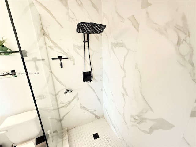 bathroom with a marble finish shower and toilet