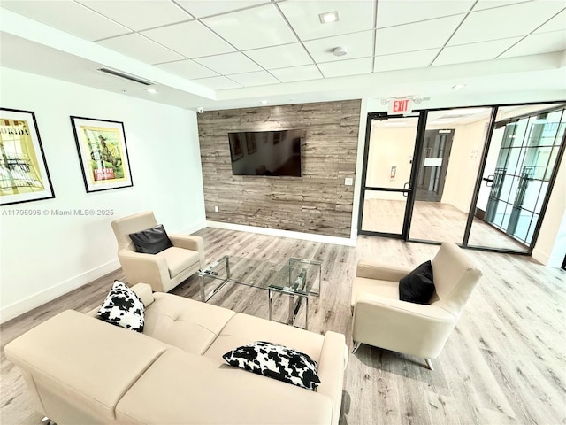 living room with baseboards, a drop ceiling, wood finished floors, and visible vents