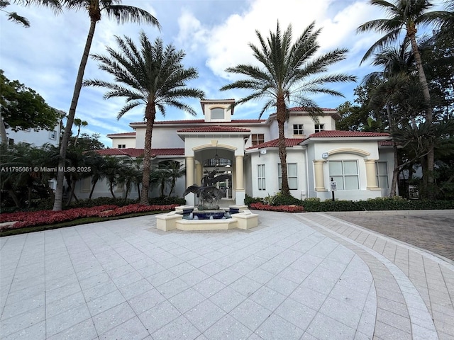 mediterranean / spanish-style home with stucco siding and a tiled roof