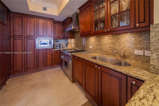 kitchen with visible vents, wall chimney exhaust hood, a sink, backsplash, and stainless steel appliances