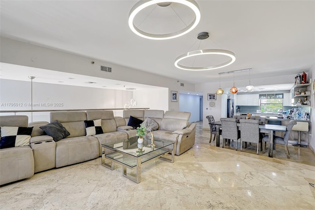 living area featuring visible vents and marble finish floor