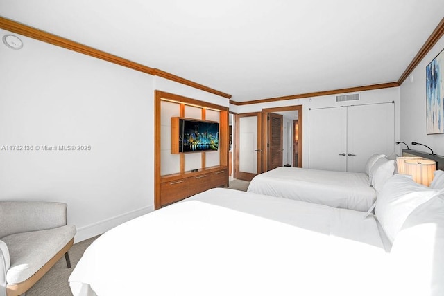 bedroom featuring visible vents, baseboards, crown molding, and carpet floors