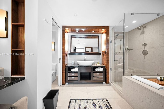 full bathroom with tile walls, a stall shower, vanity, tile patterned floors, and toilet
