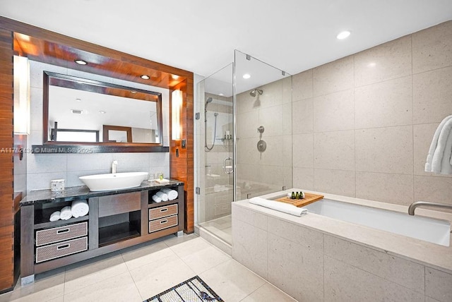 full bathroom featuring a garden tub, tile walls, tile patterned flooring, a stall shower, and vanity