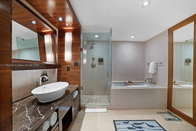 6801 Collins Ave Unit 604, Miami Beach, FL 33141 - bathroom with tile patterned floors, tile walls, a garden tub, a shower stall, and vanity