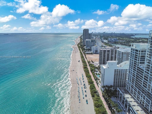birds eye view of property with a water view, a view of city, and a beach view