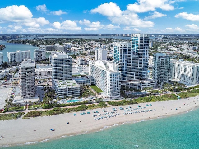 birds eye view of property featuring a water view, a view of the beach, and a view of city