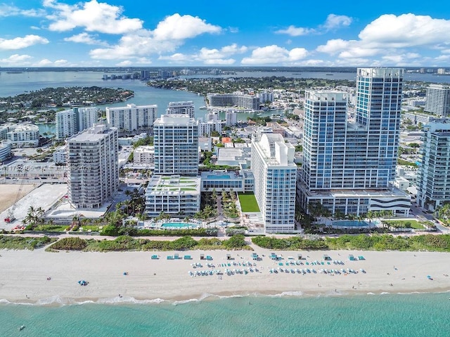 drone / aerial view featuring a beach view, a water view, and a view of city