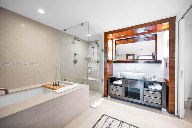 bathroom featuring a garden tub, tile walls, tile patterned flooring, a stall shower, and vanity