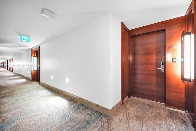 corridor featuring baseboards and carpet