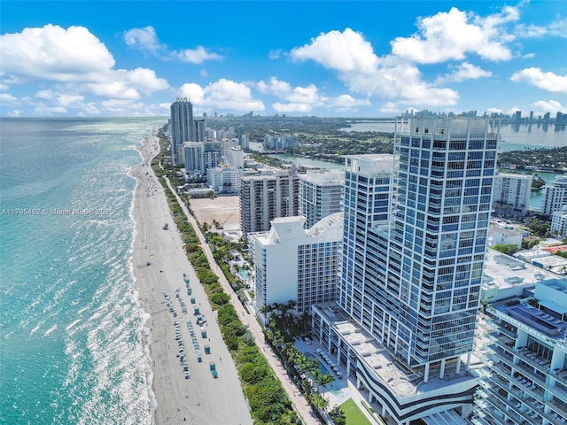 drone / aerial view with a water view, a city view, and a beach view