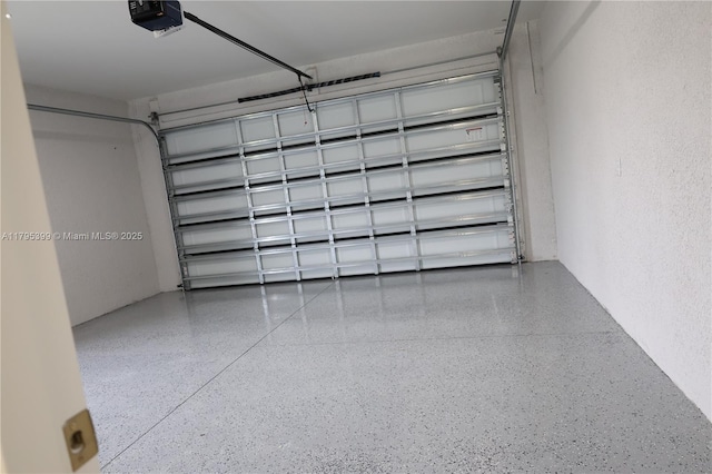 garage with a garage door opener and a textured wall
