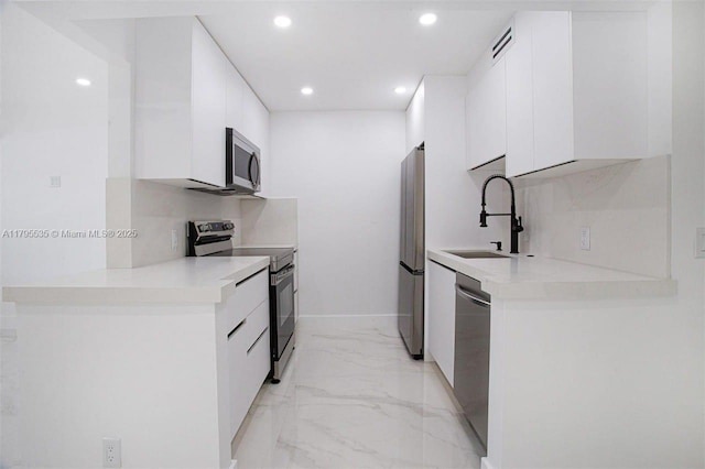 kitchen featuring modern cabinets, a sink, white cabinets, marble finish floor, and stainless steel appliances