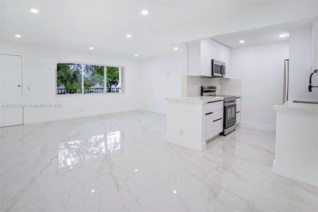 kitchen with appliances with stainless steel finishes, modern cabinets, white cabinets, marble finish floor, and recessed lighting