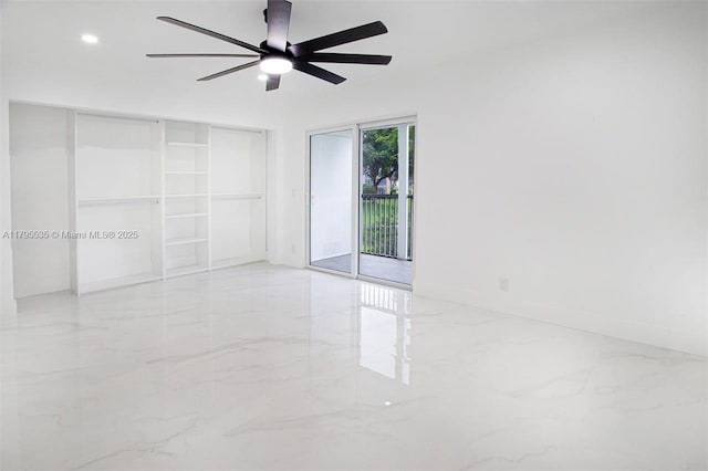 empty room with recessed lighting, a ceiling fan, and marble finish floor