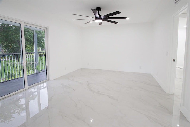 spare room featuring a ceiling fan and marble finish floor