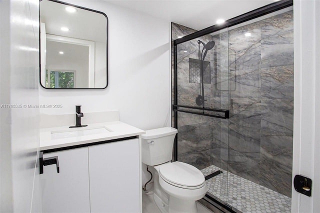bathroom featuring vanity, recessed lighting, toilet, and a shower stall