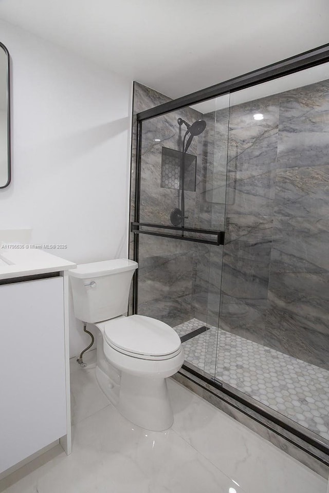full bath featuring vanity, a stall shower, and toilet