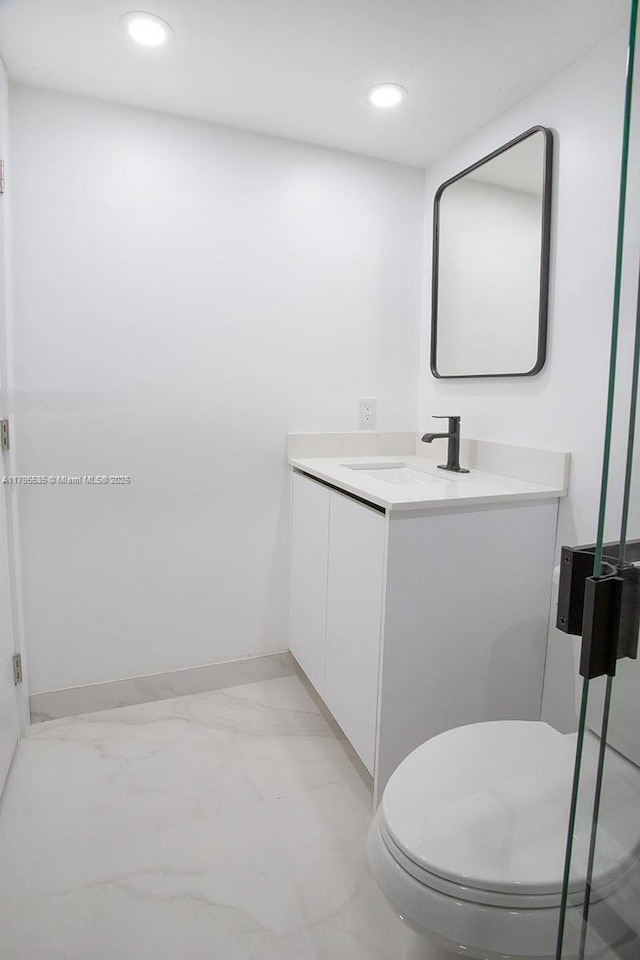 bathroom with vanity, baseboards, recessed lighting, and marble finish floor