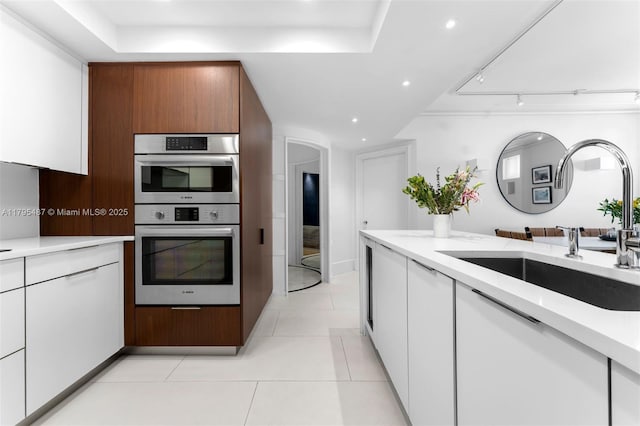 125 Jefferson Ave Unit 113, Miami Beach, FL 33139 - kitchen featuring stainless steel double oven, a sink, white cabinets, recessed lighting, and light tile patterned flooring
