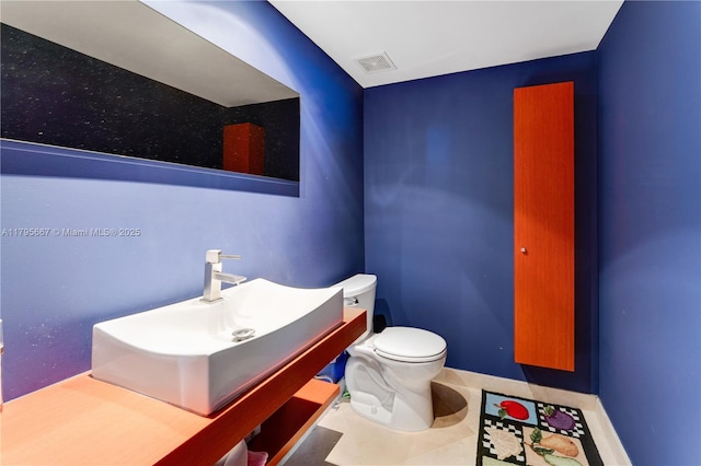 half bathroom featuring vanity, toilet, and visible vents
