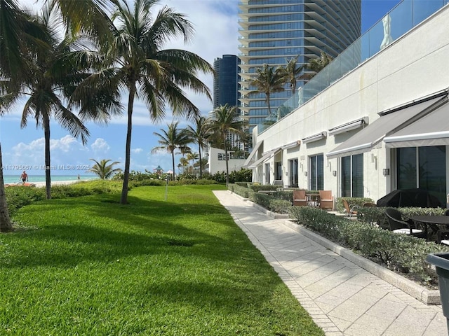 view of community with a yard and a water view