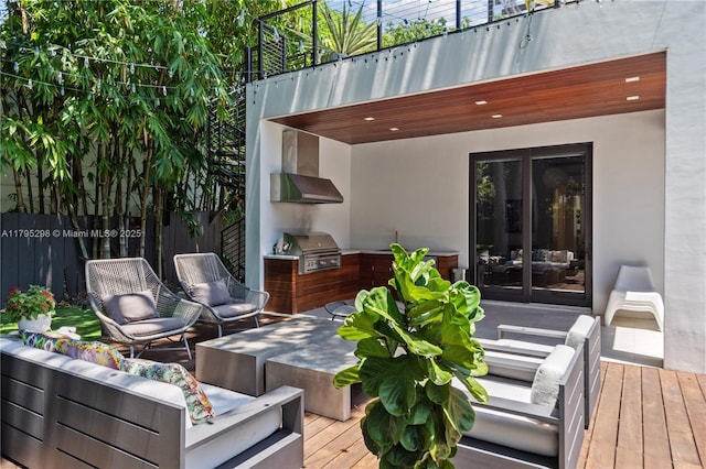 wooden terrace featuring fence, a grill, french doors, an outdoor hangout area, and exterior kitchen