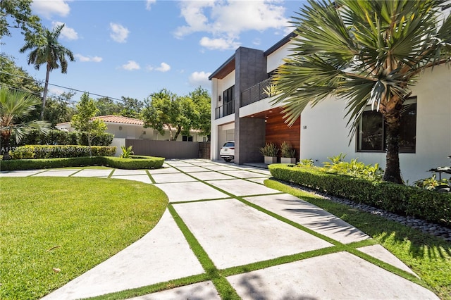view of yard featuring fence and a balcony