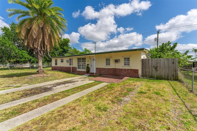single story home with brick siding, fence, and a front yard